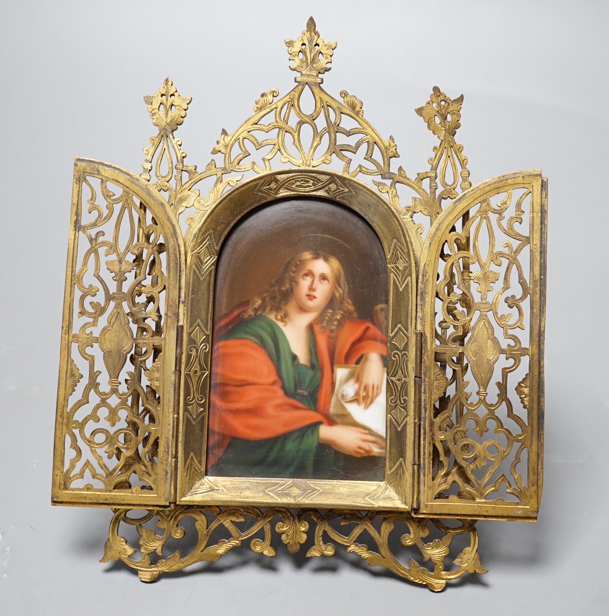 A Continental painted porcelain icon plaque in three fold pierced brass frame by Marion, London, 19cm tall